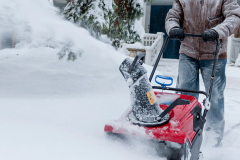 Man clearing driveway with snowblower